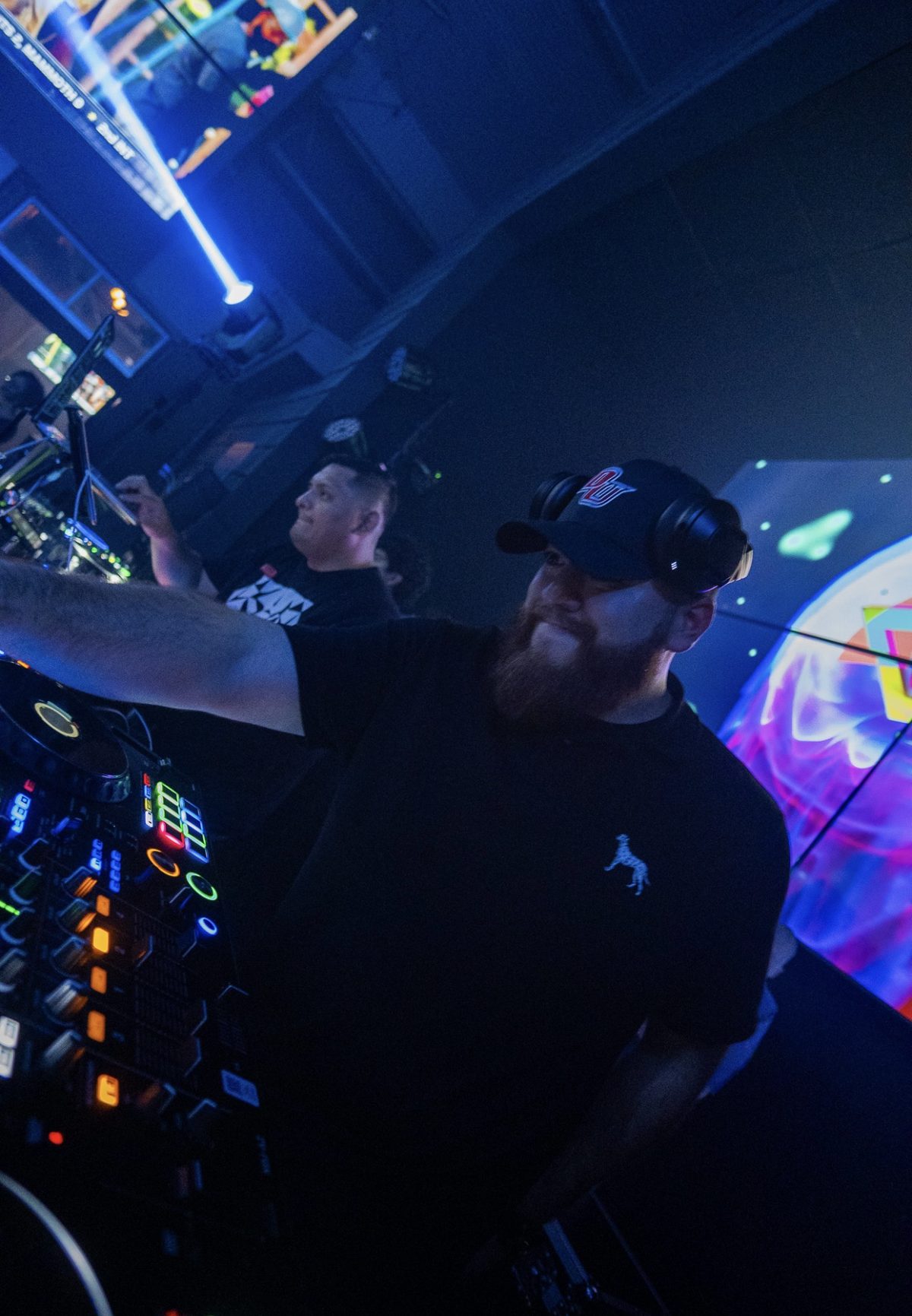 G at the decks with one arm out toward the controller